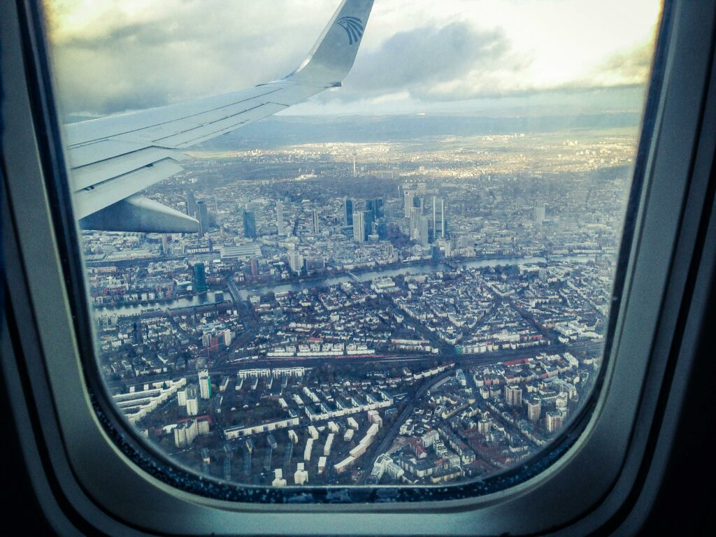 Plane window view of a city while taking off