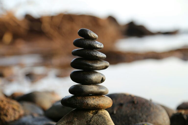 Rocks artfully arranged in a stack on the sandy beach, creating a peaceful and harmonious natural display.